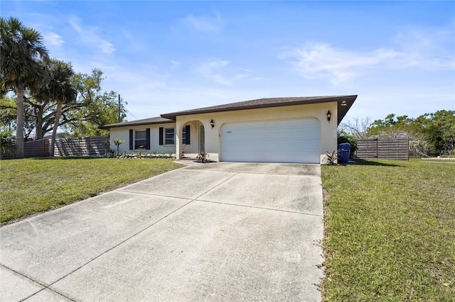 ranch-style house featuring a front lawn, fence, driveway, and stucco siding