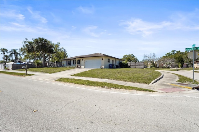 ranch-style home with a front lawn, an attached garage, fence, and driveway