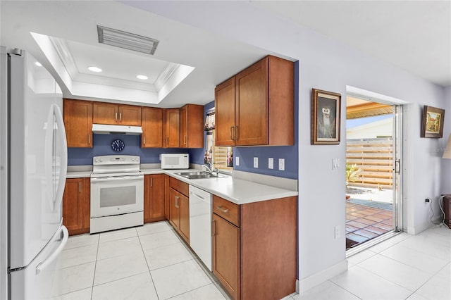 kitchen featuring visible vents, under cabinet range hood, a sink, white appliances, and a raised ceiling