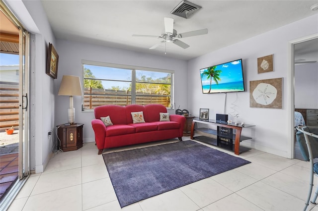 tiled living room featuring baseboards, visible vents, and ceiling fan