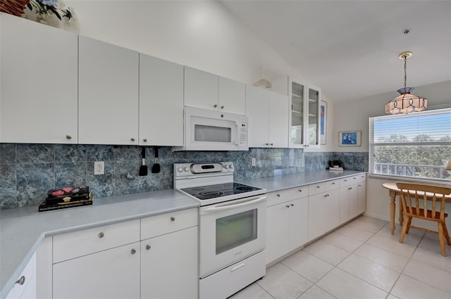 kitchen featuring lofted ceiling, light tile patterned floors, white appliances, light countertops, and tasteful backsplash