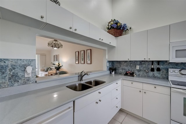 kitchen with white appliances, light tile patterned floors, decorative backsplash, light countertops, and a sink