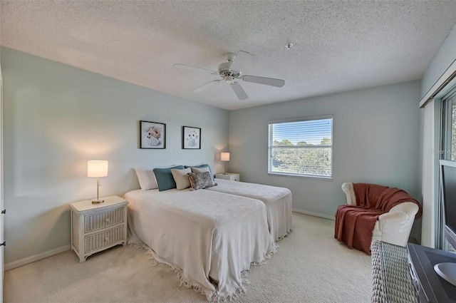 bedroom with a ceiling fan, carpet, baseboards, and a textured ceiling