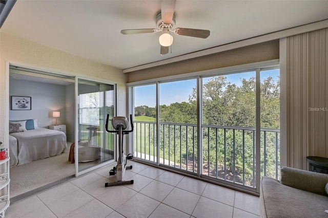 exercise room with ceiling fan and tile patterned floors