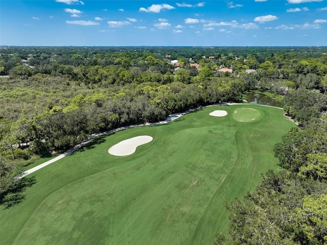 bird's eye view with golf course view and a view of trees