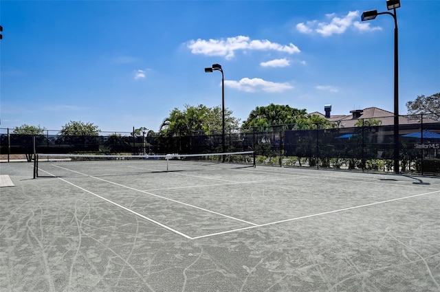 view of tennis court featuring fence