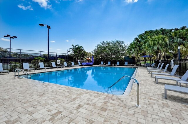 pool with a patio and fence