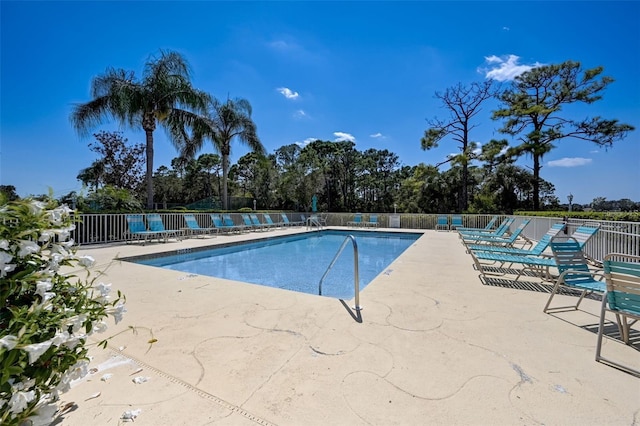 community pool featuring a patio and fence