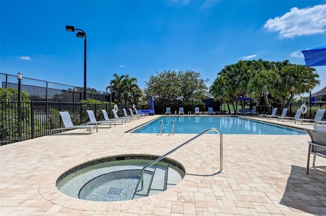 pool featuring a patio, fence, and a hot tub