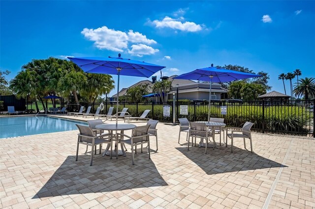 community pool with fence and a patio