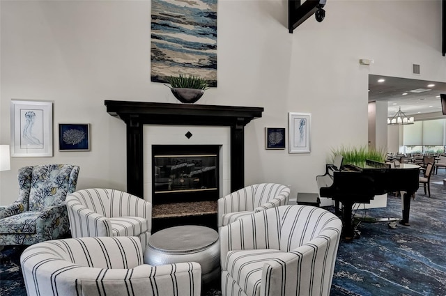 living area with carpet floors, recessed lighting, visible vents, a glass covered fireplace, and a chandelier