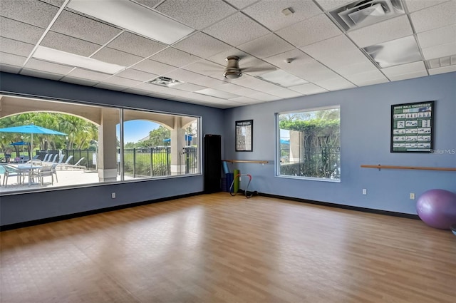 empty room featuring a healthy amount of sunlight, visible vents, and a drop ceiling