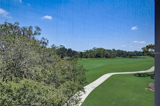 view of home's community with view of golf course and a yard