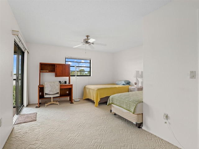 bedroom with access to outside, light colored carpet, and ceiling fan