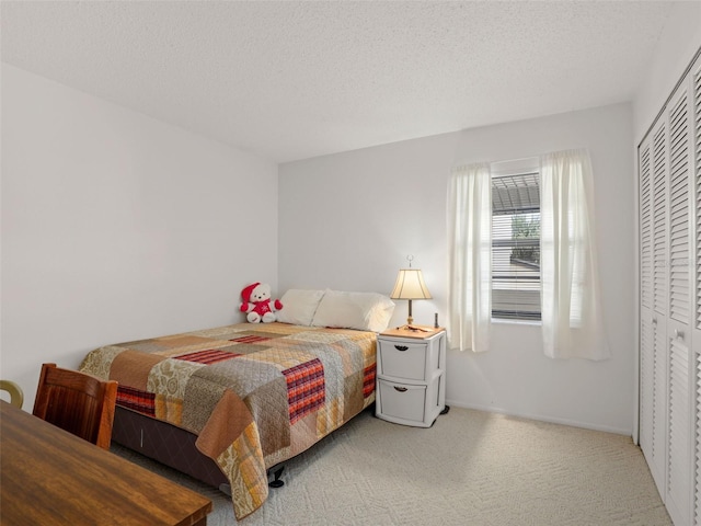 bedroom featuring a closet, a textured ceiling, and light colored carpet