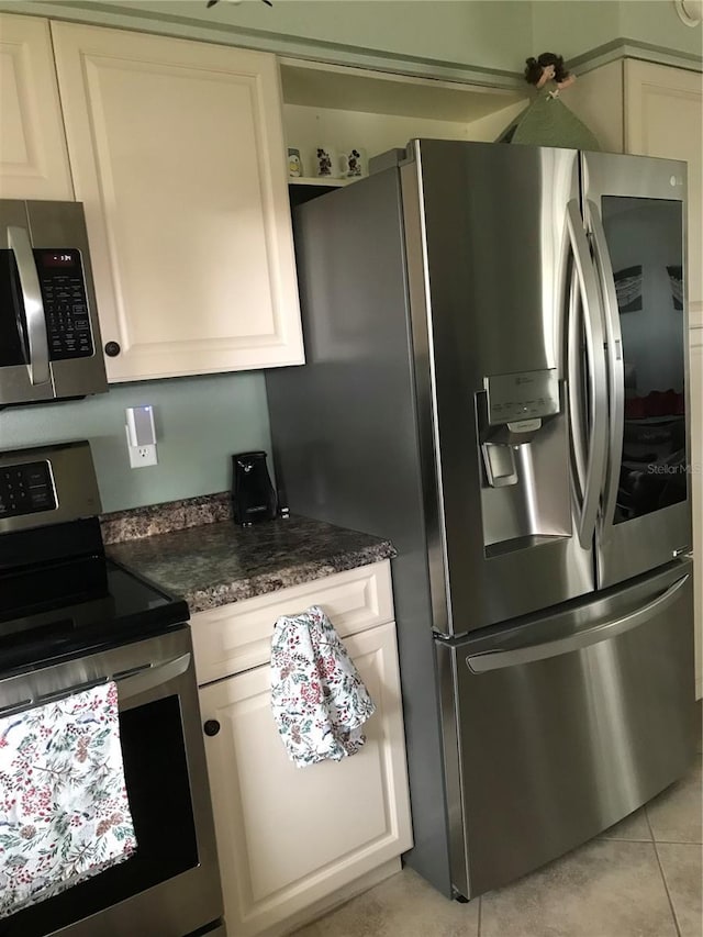 kitchen featuring appliances with stainless steel finishes, white cabinetry, and light tile patterned floors