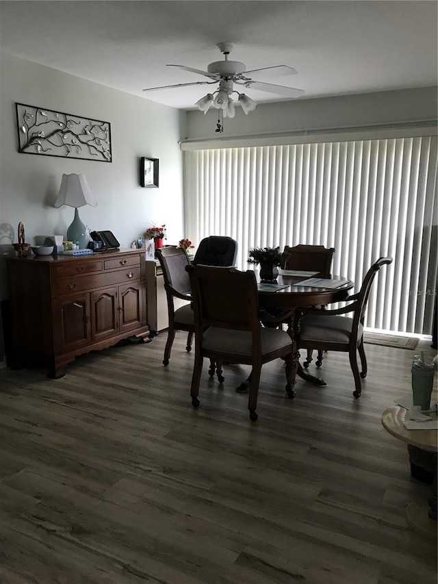 dining area featuring a ceiling fan and dark wood-style flooring