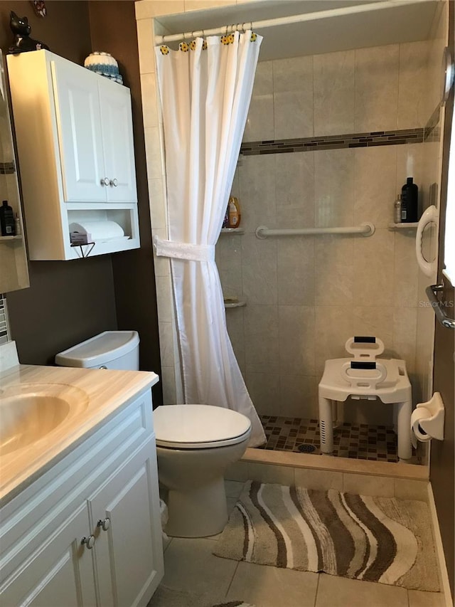 bathroom with toilet, a stall shower, tile patterned floors, and vanity