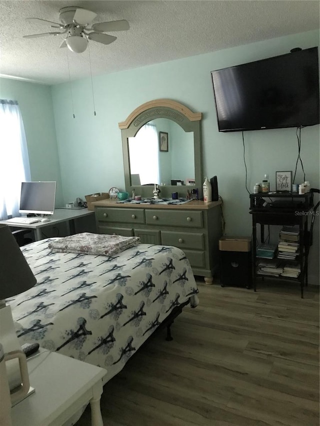 bedroom featuring a textured ceiling, wood finished floors, and a ceiling fan