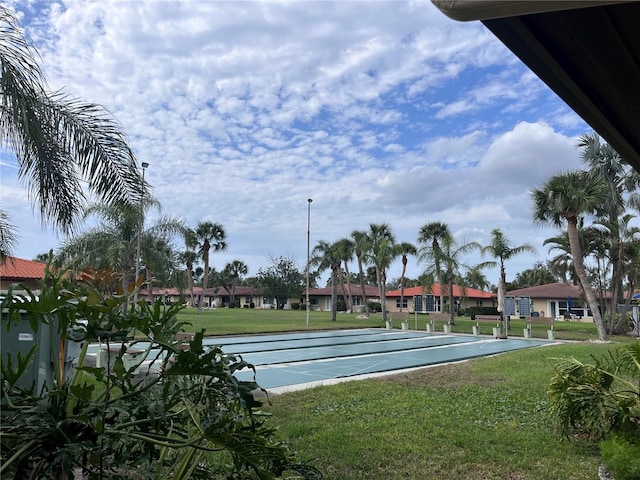 view of home's community featuring a residential view, a yard, and shuffleboard