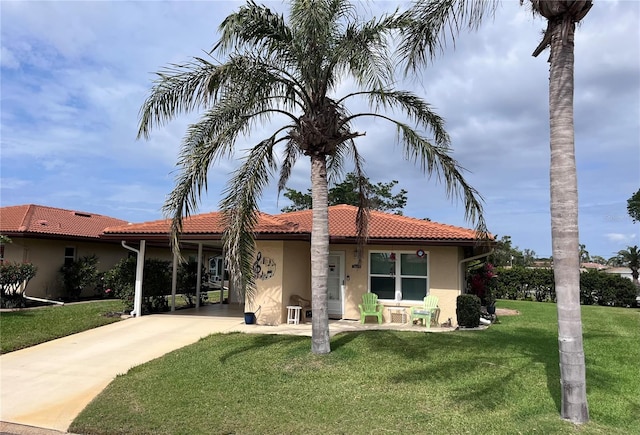 view of front facade with a front yard, a tiled roof, and stucco siding