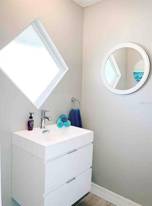 bathroom featuring wood finished floors, vanity, and baseboards