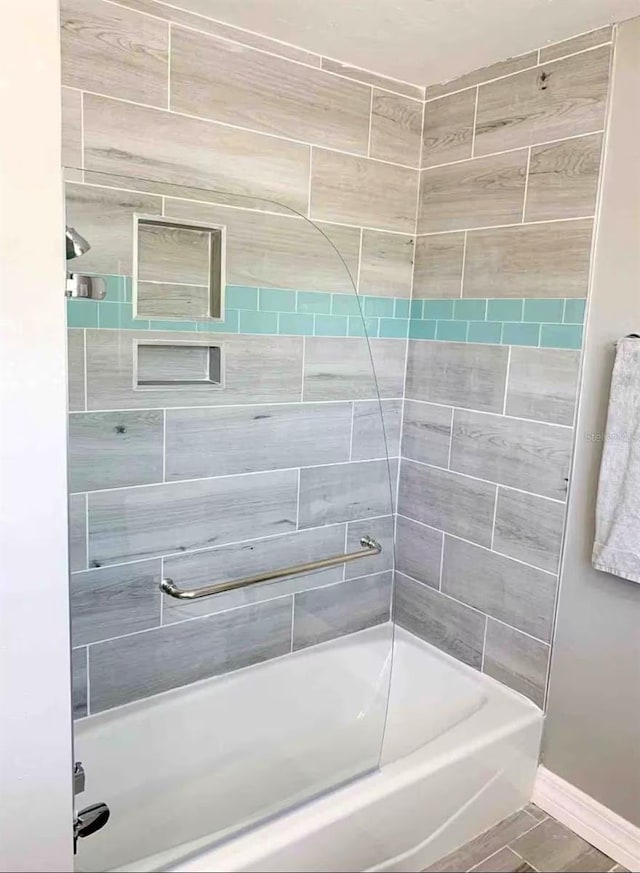 bathroom featuring shower / bath combination and baseboards