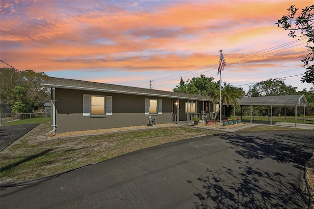 view of front of property with a front lawn, a carport, and stucco siding