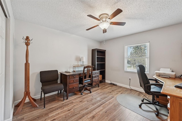 home office with a ceiling fan, a textured ceiling, baseboards, and wood finished floors