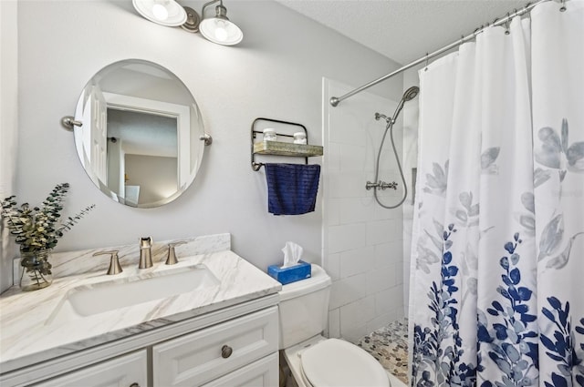 bathroom with toilet, a textured ceiling, tiled shower, and vanity