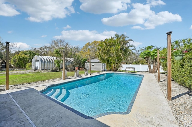 view of pool featuring an outbuilding, a fenced backyard, a yard, a fenced in pool, and a shed