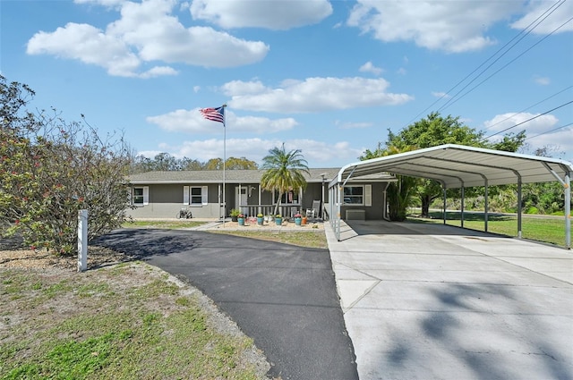 view of front of property featuring driveway, a front lawn, a carport, and stucco siding