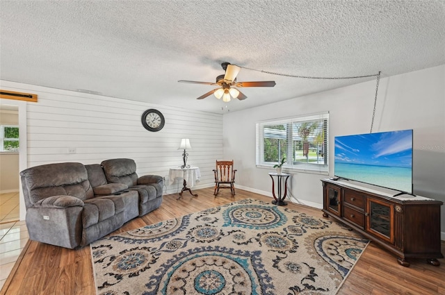 living area featuring ceiling fan, a textured ceiling, and wood finished floors