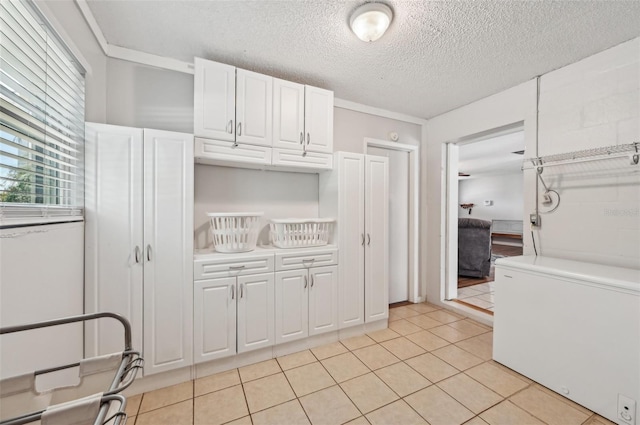 kitchen featuring light tile patterned floors, a textured ceiling, white cabinetry, light countertops, and fridge