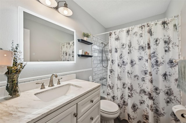 full bath featuring a textured ceiling, toilet, vanity, wainscoting, and shower / bathtub combination with curtain