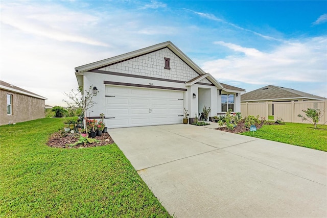 view of front of property with a garage, a front yard, driveway, and fence