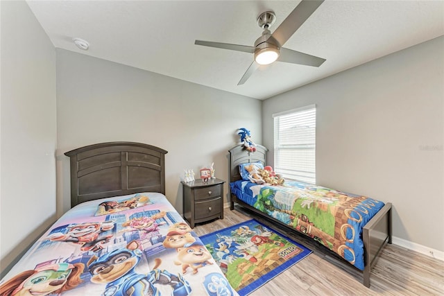 bedroom featuring a ceiling fan, light wood-type flooring, and baseboards