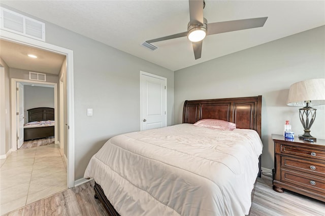 bedroom featuring light wood-style floors, visible vents, and baseboards