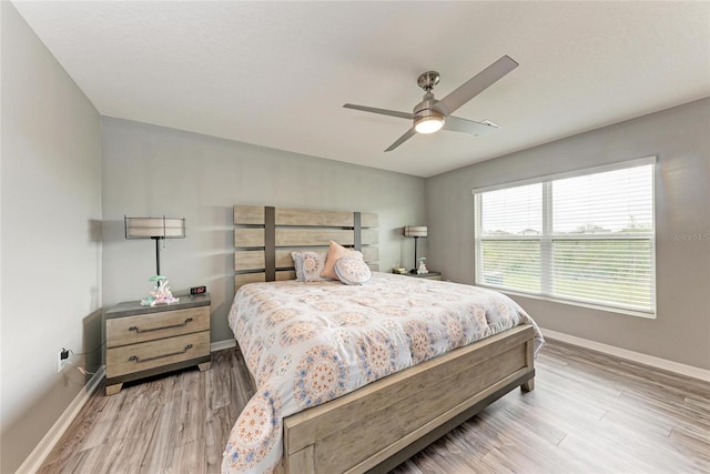 bedroom featuring light wood-style flooring, baseboards, and ceiling fan