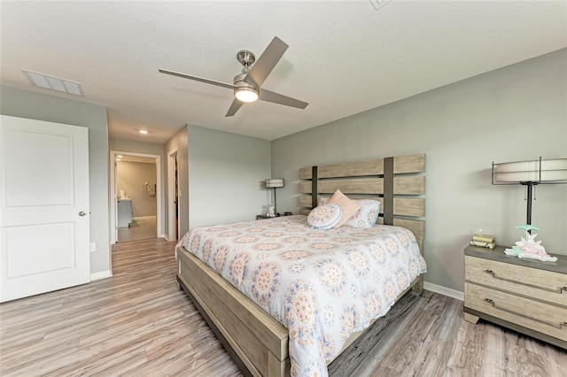 bedroom with a ceiling fan, wood finished floors, visible vents, and baseboards