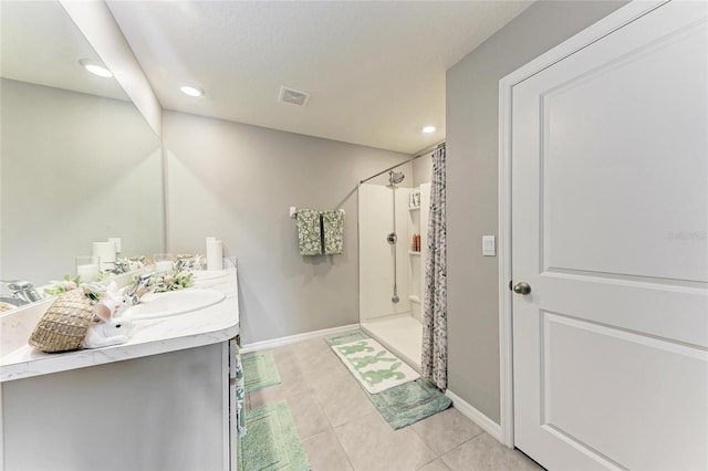 bathroom with tile patterned flooring, visible vents, baseboards, double vanity, and a stall shower