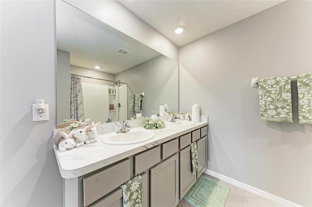 bathroom featuring double vanity, curtained shower, visible vents, a sink, and baseboards