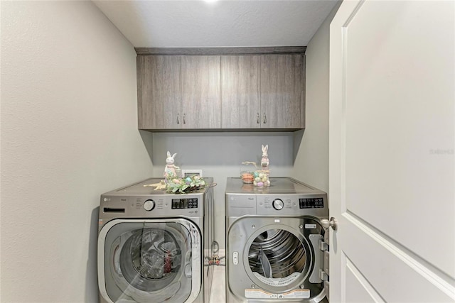 laundry room with cabinet space and washing machine and clothes dryer