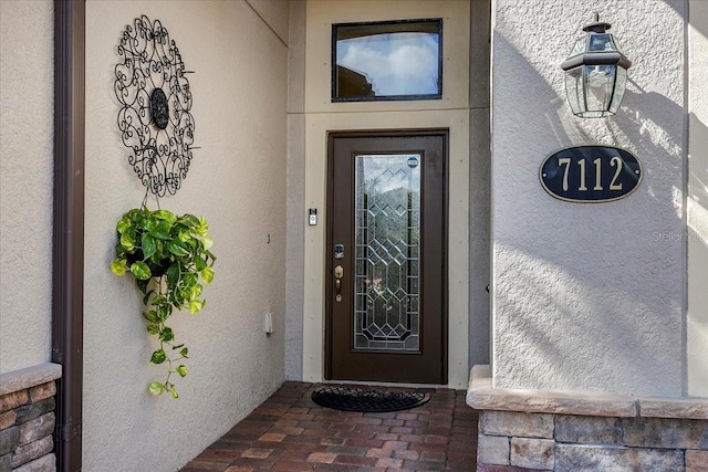 view of exterior entry with stucco siding