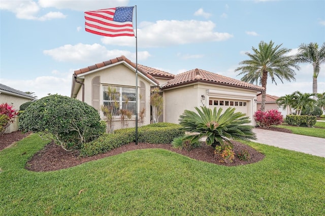 mediterranean / spanish home with an attached garage, a tiled roof, a front yard, and stucco siding