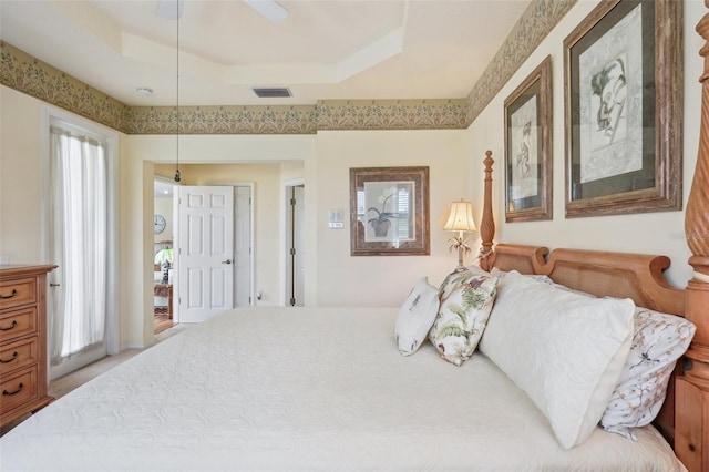 carpeted bedroom with ceiling fan, a raised ceiling, and visible vents