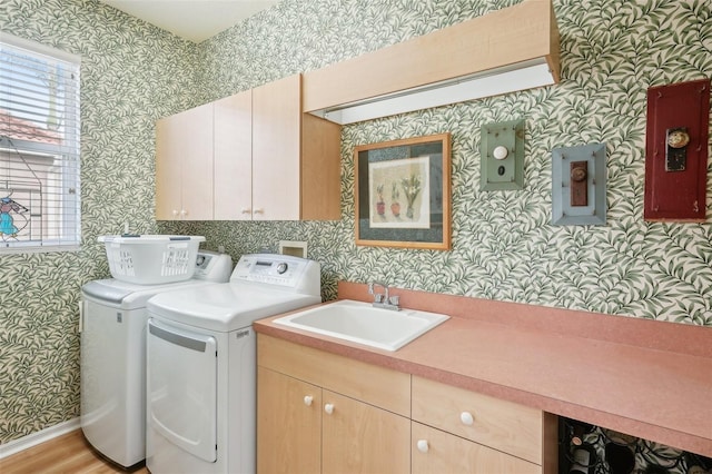 laundry room with a sink, cabinet space, and wallpapered walls