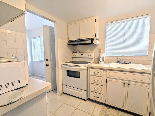 kitchen featuring light countertops, decorative backsplash, a sink, white appliances, and under cabinet range hood