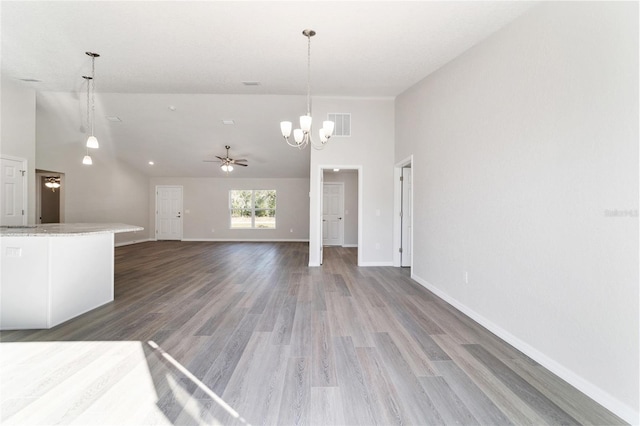 unfurnished living room with a high ceiling, wood finished floors, visible vents, and baseboards