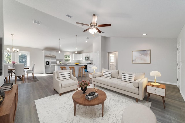 living area featuring baseboards, visible vents, wood finished floors, and ceiling fan with notable chandelier